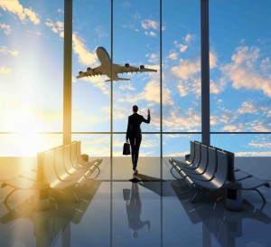 Image of woman in airport looking at taking off airplane